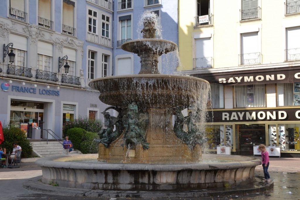 La niña jugando con el agua de la fuente